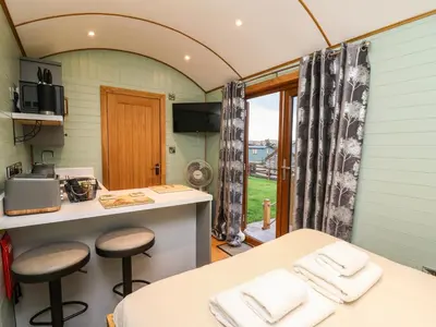 a kitchen with a counter and stools in a room at Highland View in Rhayader