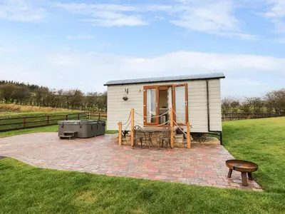 a tiny house with a patio and a grill at Highland View in Rhayader