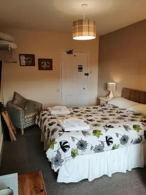 a hotel room with a bed and a couch and a bed sidx sidx at Lion Hotel in Llanbister