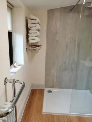 a bathroom with a shower with towels on a wall at Lion Hotel in Llanbister