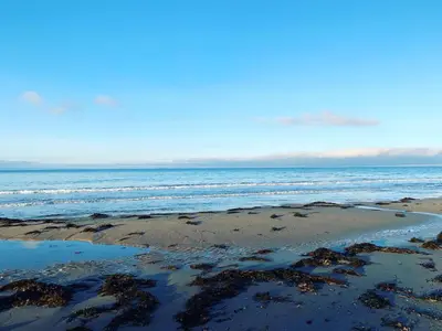 a sandy beach with the ocean in the background at Bwthyn Nain Cottage near Harlech with ocean views in Llanfair