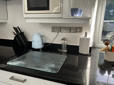 a kitchen with a counter top with a microwave at Bwthyn Nain Cottage near Harlech with ocean views in Llanfair