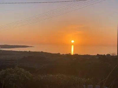 a sunset over the water with the sun in the sky at Bwthyn Nain Cottage near Harlech with ocean views in Llanfair