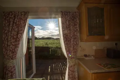a kitchen with a window with a view of a field at Goitre Bach Cottage in Aberaeron
