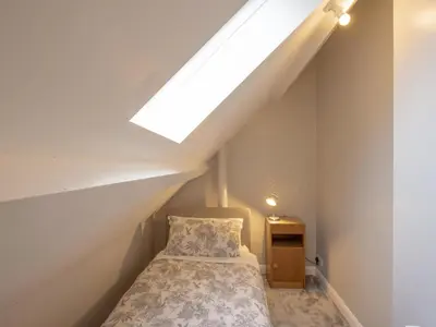 a attic bedroom with a bed and a skylight at The Coach House in Oswestry