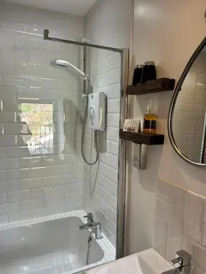 a bathroom with a shower and a tub and a sink at Cadwgan House in Rhayader