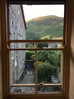 an open window with a view of a building at Chapel Cottage in Machynlleth