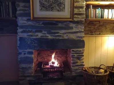 a brick fireplace with a fire in it at Chapel Cottage in Machynlleth