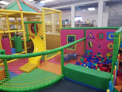 an indoor play room with a play gym with balls at C8 in Aberystwyth