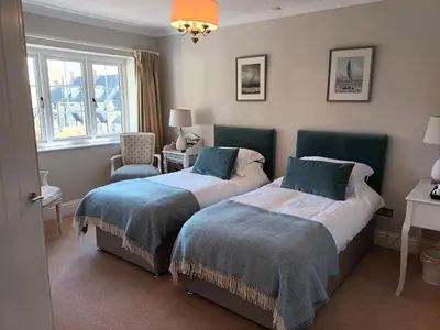 a bedroom with two beds and a chair and a window at Baskerville House in Clyro