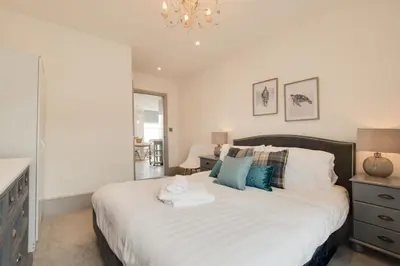 a bedroom with a large bed and a chandelier at 1 Bed in Aberystwyth oc-bow286 in Aberystwyth