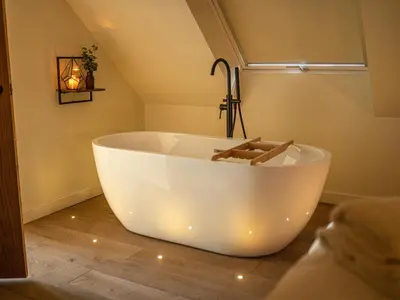 a large white bath tub in a bathroom at Tyn Llwyn Barn in Corwen