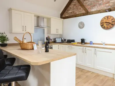 a kitchen with white cabinets and a wooden counter top at The Clockhouse in Llandyssil