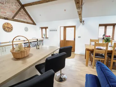 a kitchen and dining room with a table and chairs at The Clockhouse in Llandyssil
