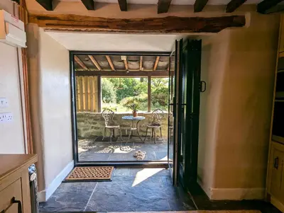 an open door to a patio with a table and chairs at Panoramic Mountain Retreat - Waen Fechan - 4x4 access only in Dolgellau