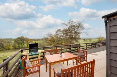 a patio with a table and chairs and a laptop at 2 Bed in Y Drenewydd oc-waa401 in Llanllugan
