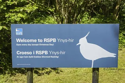 a blue sign with a white bird on it at 2 Bed in Y Drenewydd oc-waa401 in Llanllugan