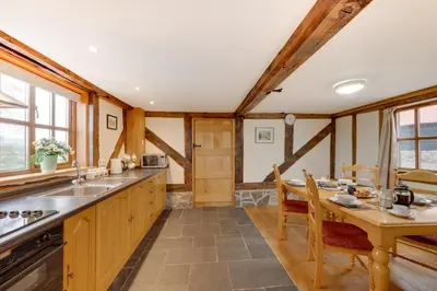 a kitchen with a table and a dining room at 2 Bed in Y Drenewydd oc-waa401 in Llanllugan