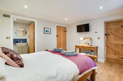 a bedroom with a large bed and a bathroom at 4 Bed in Dinas Mawddwy oc-bow305 in Aber Cowarch