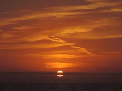 a sunset over the ocean with the sun in the sky at Leahurst Bed and Breakfast in Tywyn