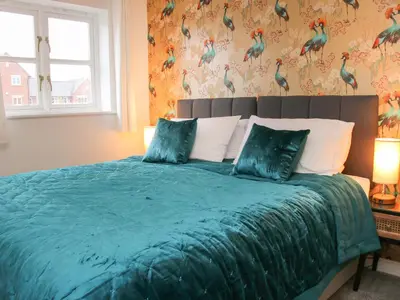 a bedroom with a bed with a green comforter at Pippin's Place in Shrewsbury