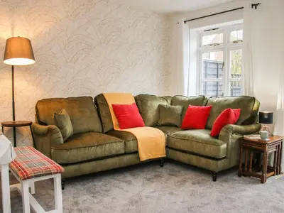 a living room with a green couch and red pillows at Pippin's Place in Shrewsbury