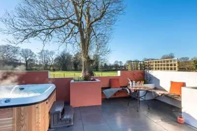 a patio with a hot tub and a tree at 2 Bed in Tregaron oc-bow298 in Tregaron