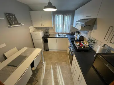 a kitchen with white cabinets and a black counter top at Westend Holiday Let 3 Brecon in Brecon