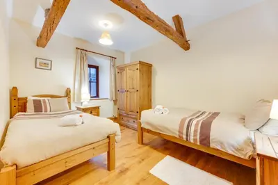 two beds in a bedroom with wooden floors at 2 Bed in Y Drenewydd oc-waa402 in Llanllugan