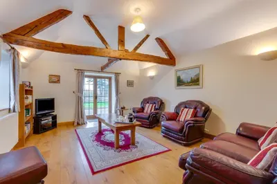 a living room with leather chairs and a table at 2 Bed in Y Drenewydd oc-waa402 in Llanllugan