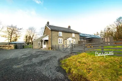a house with a fence and a gravel driveway at 3 Bed in Machynlleth oc-bow306 in Darowen