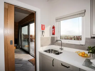 a kitchen with a sink and a window at Hilltop Lodge in Corwen