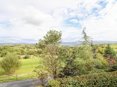 a view of a field with trees and a fence at Hilltop Lodge in Corwen