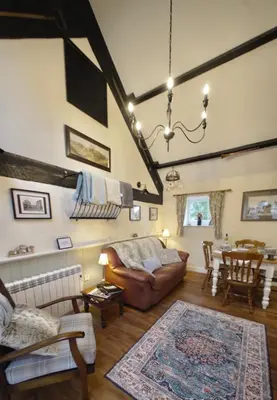 a living room with a couch and a table at The Old Milking Parlour Flyingpiglets in Llandovery