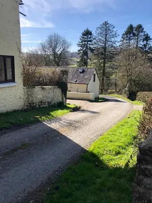 an empty road next to a house with a building at The Old Milking Parlour Flyingpiglets in Llandovery