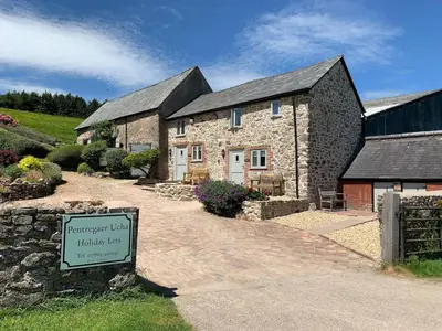 a stone house with a sign in front of it at The Stables at Pentregaer Ucha, tennis court & lake in Oswestry