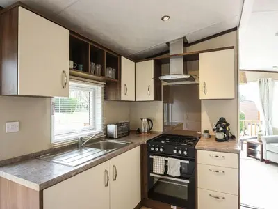 a kitchen with a sink and a stove top oven at Avon Lodge in Hyssington