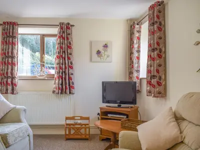 a living room with a couch and a tv at Border View in Kington