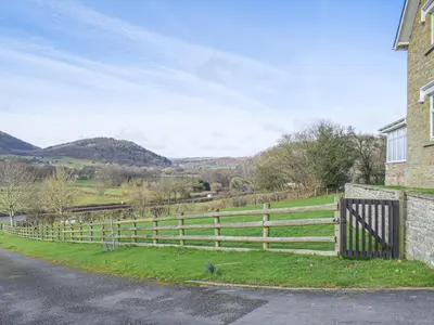 a fence on the side of a road next to a house at Border View in Kington