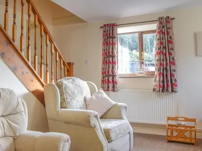 a living room with a chair and a window at Border View in Kington
