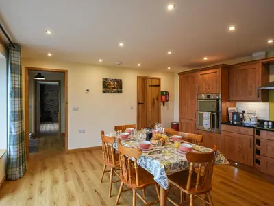 a kitchen and dining room with a table and chairs at Yr Hen Feudy At Pentre Farm in Llansilin