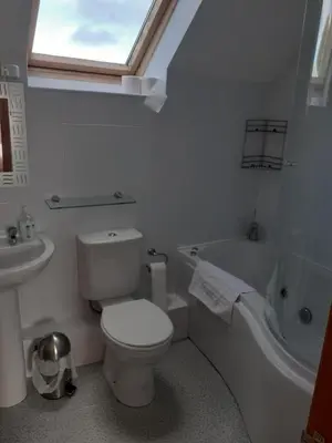 a bathroom with a toilet and a tub and a sink at The Granary, Bryncarnedd cottages in Aberystwyth