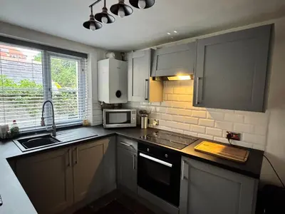 a small kitchen with a sink and a microwave at Abbey Cottage in Llangollen