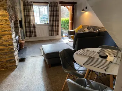 a living room with a couch and a table at Abbey Cottage in Llangollen