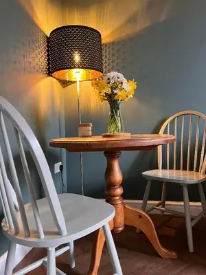 a table with a vase of flowers and two chairs at Cartref - Fully equipped and stunning town flat in Shrewsbury
