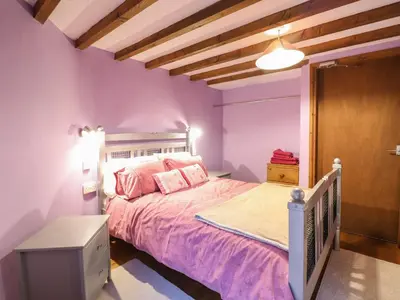 a bedroom with purple walls and a bed with pink sheets at Yr Hen Felin in Oswestry