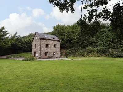 an old stone house in a field of grass at Yr Hen Felin in Oswestry