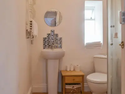 a bathroom with a sink and a toilet at The Snug in Aberaeron