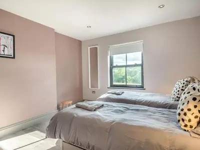 a bedroom with two beds and a window at Gwrlodde in Talgarth