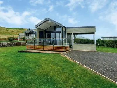 a large house with a large deck in a yard at Lake Vyrnwy Luxury Glamping Pod 2 in Llanwddyn